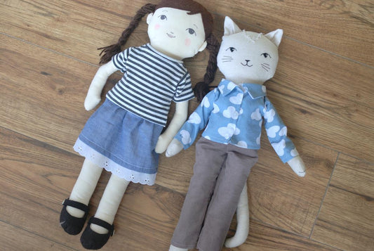 two rag dolls wearing tops, skirt, and pants