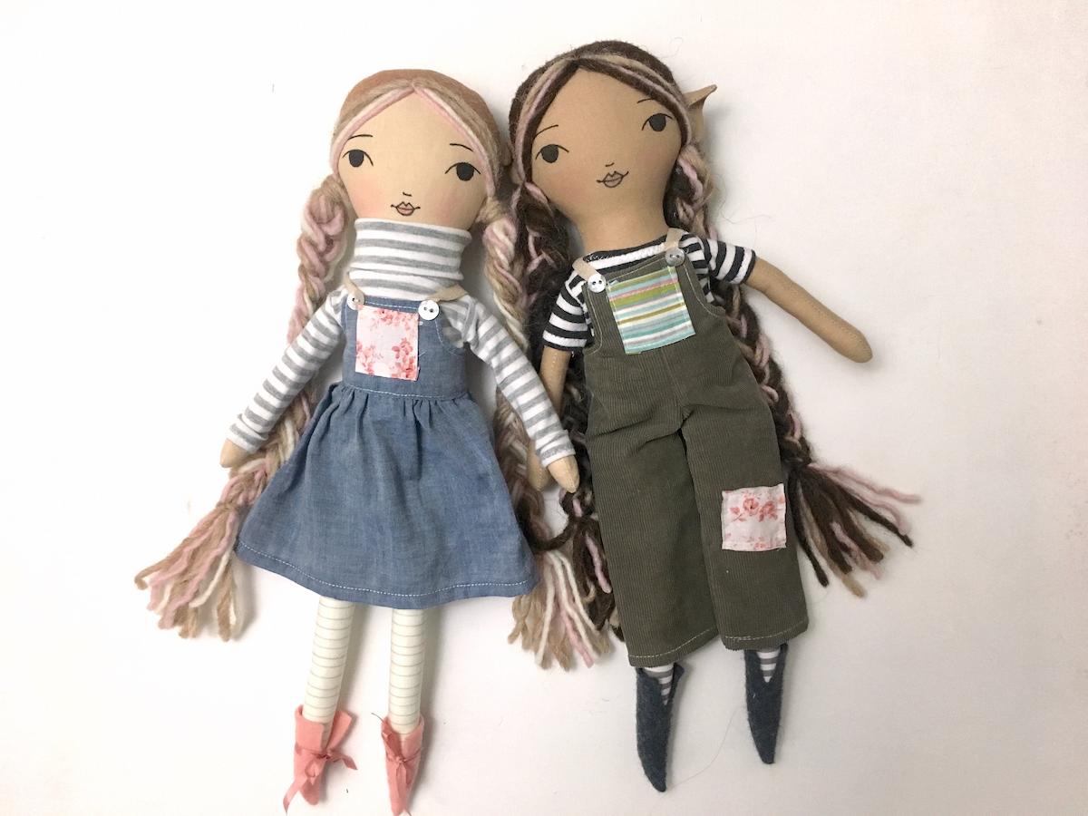 two rag dolls wearing pinafore and overalls